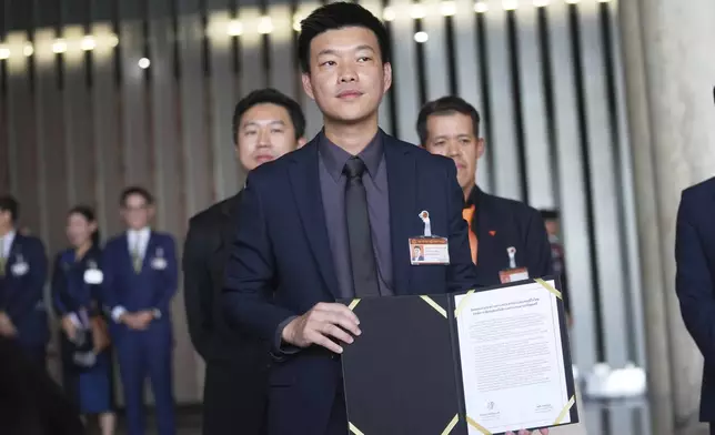 Leader of People's Party, Natthaphong Ruengpanyawut shows the signed Memorandum of Understanding between his party and Bhumjai Thai Party at Parliament in Bangkok, Thailand, Wednesday, Sept. 3, 2025. (AP Photo/Sakchai Lalit)