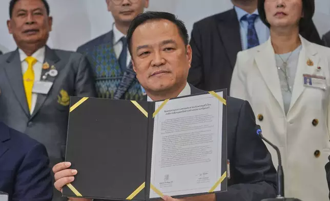 Leader of Bhumjai Thai Party Anutin Charnvirakul shows the signed Memorandum of Understanding between his coalition parties and the People's party at Parliament in Bangkok, Thailand, Wednesday, Sept. 3, 2025. (AP Photo/Sakchai Lalit)