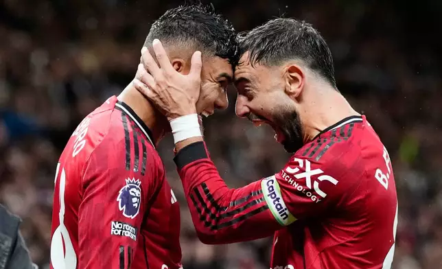 Manchester United's Casemiro, left, celebrates with Bruno Fernandes after scoring their second goal during the English Premier League soccer match between Manchester United and Chelsea at the Old Trafford stadium in Manchester, England, Saturday, Sept. 20, 2025. (Nick Potts/PA via AP)