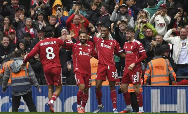 Liverpool's Ryan Gravenberch, second right, celebrates with teammates after scoring his side's opening goal during the English Premier League soccer match between Liverpool and Everton at Anfield stadium in Liverpool, England, Saturday, Sept. 20, 2025. (AP Photo/Rui Vieira)