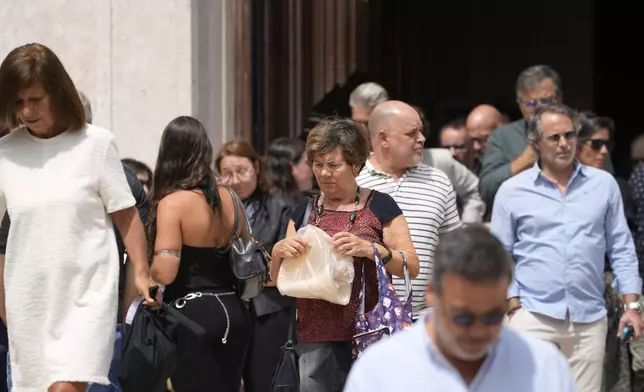 Relatives, friends and colleagues leave a church service for the four coworkers of the charitable organization Santa Casa da Misericordia who perished in the derailment and crash of the Gloria funicular, at the Church of Saint Roch in Lisbon, Friday, Sept. 5, 2025. (AP Photo/Armando Franca)