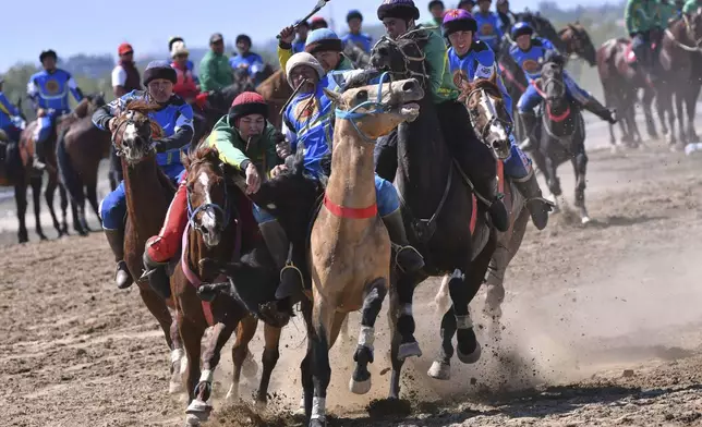 Kyrgyz horse riders compete during a kok boru, also called ulak tartysh, a traditional game in which players on horseback manoeuvre with a goat's carcass and score by putting it into the opponents' goal at the 25th Kok Boru President's Cup near Cholpon-Ata, 204km (127,5 miles) southeast of Bishkek, in the Issyk-Kul Region of Kyrgyzstan, Thursday, Sept. 4, 2025. (AP Photo/Vladimir Voronin)