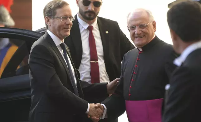 Israel's President Isaac Herzog, left, is greeted by Monsignor Leonardo Sapienza as he arrives in the St. Damasus courtyard at The Vatican on his way to a private audience with Pope Leo XIV, Thursday, Sep. 4, 2025. (AP Photo/Domenico Stinellis)