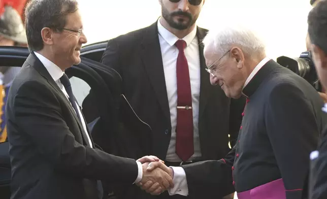 Israel's President Isaac Herzog, left, is greeted by Monsignor Leonardo Sapienza as he arrives in the St. Damasus courtyard at The Vatican on his way to a private audience with Pope Leo XIV, Thursday, Sep. 4, 2025. (AP Photo/Domenico Stinellis)