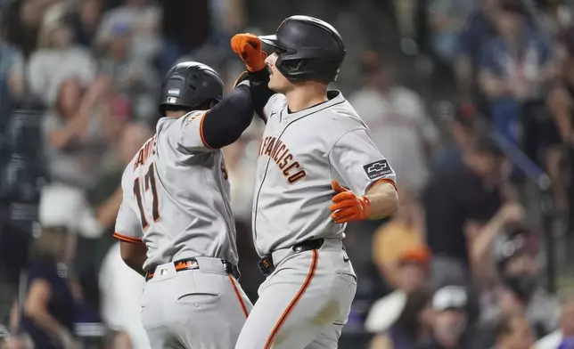 San Francisco Giants' Heliot Ramos, left, congratulates Matt Chapman as he crosses home plate after hitting a three-run home run off Colorado Rockies relief pitcher Juan Mejia in the sixth inning of a baseball game Wednesday, Sept. 3, 2025, in Denver. (AP Photo/David Zalubowski)