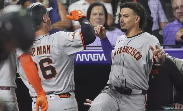 San Francisco Giants' Willy Adames, right, congratulates Matt Chapman as he returns to the dugout after hitting a three-run home run off Colorado Rockies relief pitcher Juan Mejia in the sixth inning of a baseball game Wednesday, Sept. 3, 2025, in Denver. (AP Photo/David Zalubowski)