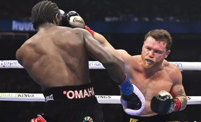 Canelo Alvarez, right, punches Terence Crawford during an undisputed super middleweight championship boxing match in Las Vegas, Saturday, Sept. 13, 2025. (AP Photo/David Becker)
