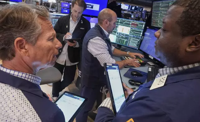Traders Robert Charmak, left, Thomas Lee, right, and Ben Tuchman, background left, work with specialist James Denaro on the floor of the New York Stock Exchange, Friday, Sept. 5, 2025. (AP Photo/Richard Drew)