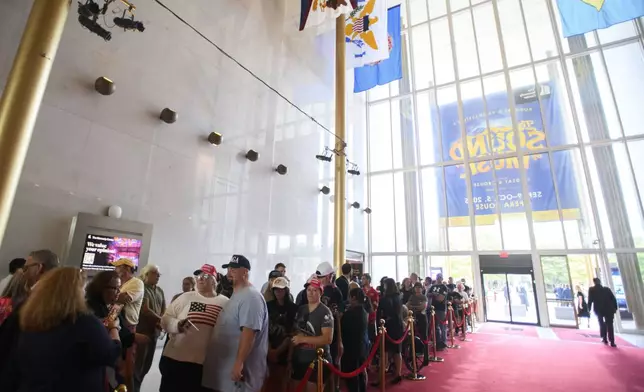 People wait in line for a memorial and prayer vigil for Charlie Kirk at the John F. Kennedy Memorial Center for the Performing Arts, Sunday, Sept. 14, 2025, in Washington. (AP Photo/Rod Lamkey, Jr.)