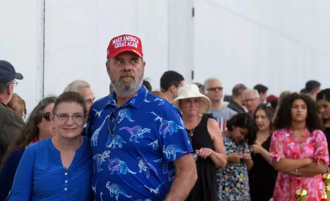 Kevin Vanriper, right, and his wife Barbara Vanriper, left, of Sarasota, Fla., join other people waiting in line for a memorial and prayer vigil for Charlie Kirk at the John F. Kennedy Memorial Center for the Performing Arts, Sunday, Sept. 14, 2025, in Washington. (AP Photo/Rod Lamkey, Jr.)