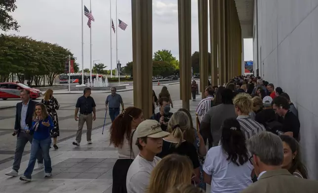 People wait in line for a memorial and prayer vigil for Charlie Kirk at the John F. Kennedy Memorial Center for the Performing Arts, Sunday, Sept. 14, 2025, in Washington. (AP Photo/Rod Lamkey, Jr.)