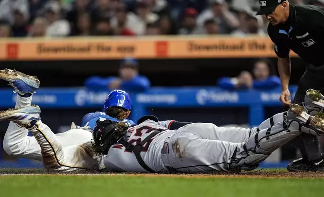 Minnesota Twins Austin Martin (16) scores on a loose ball against Cleveland Guardians catcher Bo Naylor (23) in the sixth inning of a baseball game, Friday, Sept. 19, 2025, in Minneapolis. (AP Photo/Mike Stewart)