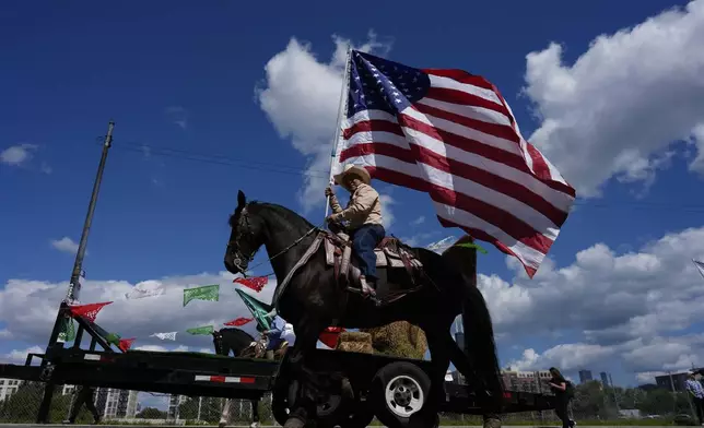 Participants wave flags during the 2025 Pilsen Mexican Independence Day parade Saturday, Sept. 6, 2025, in Chicago. (AP Photo/Carolyn Kaster)
