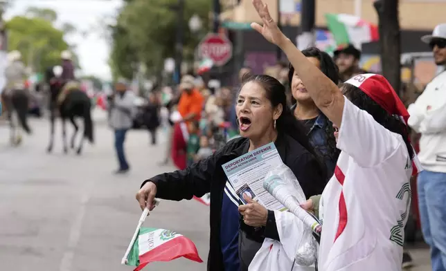 People wave flags a s they watch during the 2025 Pilsen Mexican Independence Day parade Saturday, Sept. 6, 2025, in Chicago. (AP Photo/Carolyn Kaster)