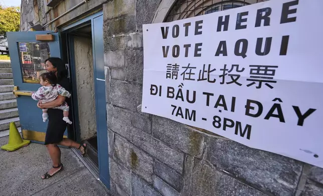 Boston Mayor Michelle Wu carries her daughter Mira after voting at a polling place, Tuesday, Sept. 9, 2025, in the Roslindale neighborhood of Boston. (AP Photo/Charles Krupa)