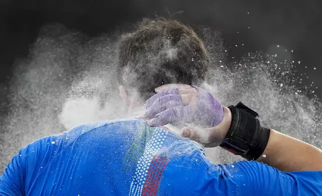 Italy's Leonardo Fabbri chalks his neck as he competes in the men's shot put final at the World Athletics Championships in Tokyo, Saturday, Sept. 13, 2025. (AP Photo/Ashley Landis)
