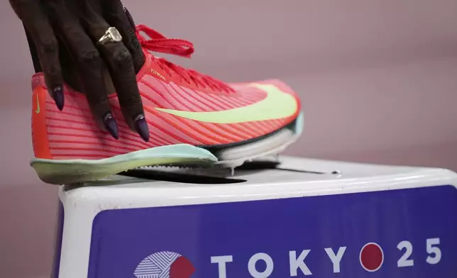 Britain's Victoria Ohuruogu adjusts her footwear as she prepares to compete in the women's 400 meters heat at the World Athletics Championships in Tokyo, Sunday, Sept. 14, 2025. (AP Photo/Eugene Hoshiko)