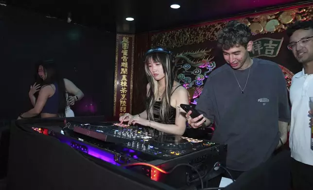 A DJ plays music at an event organized by the YLL Mahjong Club on Friday, Aug. 15, 2025, in San Francisco. (AP Photo/Terry Chea)