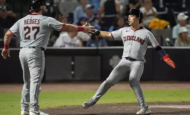 Cleveland Guardians' Austin Hedges (27) and Steven Kwan celebrate after scoring on a two-run double by José Ramírez off Tampa Bay Rays pitcher Ian Seymour during the second inning of a baseball game Friday, Sept. 5, 2025, in Tampa, Fla. (AP Photo/Chris O'Meara)
