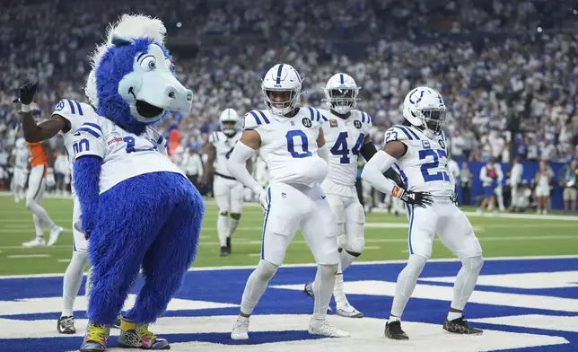 Indianapolis Colts safety Cam Bynum (0) celebrates an interception with the Indianapolis Colts mascot Blue and cornerback Kenny Moore II (23) during the second half an NFL football game against the Denver Broncos, Sunday, Sept. 14, 2025, in Indianapolis. (AP Photo/Michael Conroy)