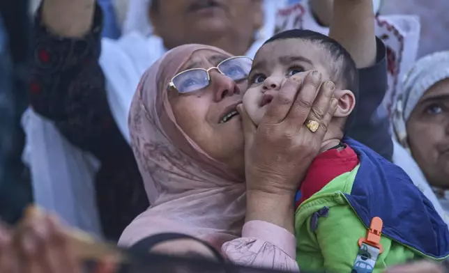 Kashmiri devotees raise their hands towards a relic, believed to be a hair from the beard of Islam's Prophet Muhammad, being displayed by a priest at the Hazratbal shrine on the Friday following Eid-e-Milad, marking the birth anniversary of the Prophet, in Srinagar, Indian controlled Kashmir, Friday, Sept. 12, 2025. (AP Photo/Dar Yasin)