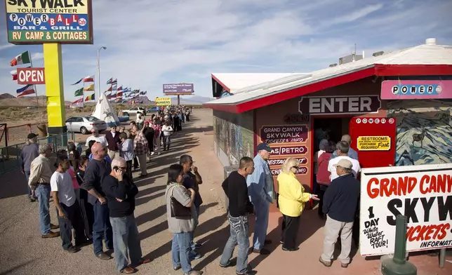 FILE - A crowd of people line up outside the Arizona Last Stop convenience store and souvenir shop to buy Powerball tickets, Tuesday, Nov. 27, 2012, in White Hills, Ariz. AP Photo/Julie Jacobson, File)