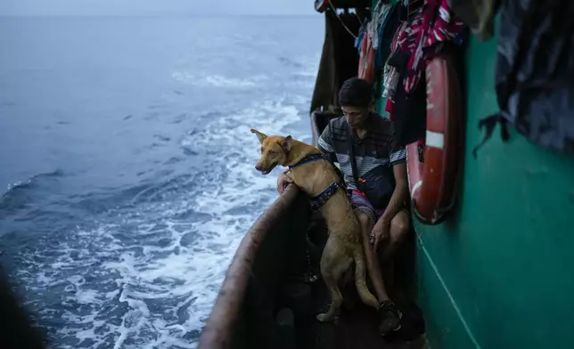 Venezuelan Abraham Castro rides a cargo vessel with other Venezuelan migrants through the Gulf of Panama as he, his partner and her two sons travel south after giving up on reaching the United States, Wednesday, Sept. 17, 2025. (AP Photo/Matias Delacroix)