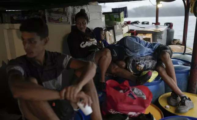 Venezuelan migrants Mariela Gomez, her two sons, and partner Abraham Castro return home on a cargo vessel on Panama's Pacific coast, Thursday, Sept. 18, 2025. The family is returning south after being detained by U.S. authorities in Texas and sent to southern Mexico. (AP Photo/Matias Delacroix)
