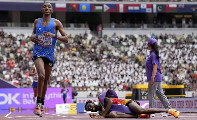 Tanzania's Alphonce Felix Simbu, left, wins the gold in the men's marathon ahead of Germany's Amanal Petros who falls at the World Athletics Championships in Tokyo, Monday, Sept. 15, 2025. (AP Photo/Petr David Josek)