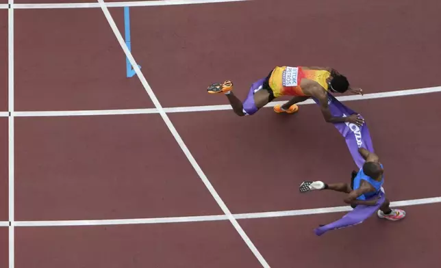 Tanzania's Alphonce Felix Simbu, bottom, crosses the finish line ahead of Germany's Amanal Petros to win the men's marathon at the World Athletics Championships in Tokyo, Monday, Sept. 15, 2025. (AP Photo/Bernat Armangue)