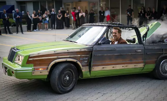 Producer Ryan Reynolds and director Colin Hanks drive in a replica prop car from the movie "Planes, Trains and Automobiles" prior to the premiere of "John Candy: I Like Me" at the Toronto International Film Festival, in Toronto on Thursday, Sept. 4, 2025. (Arlyn McAdorey/The Canadian Press via AP)
