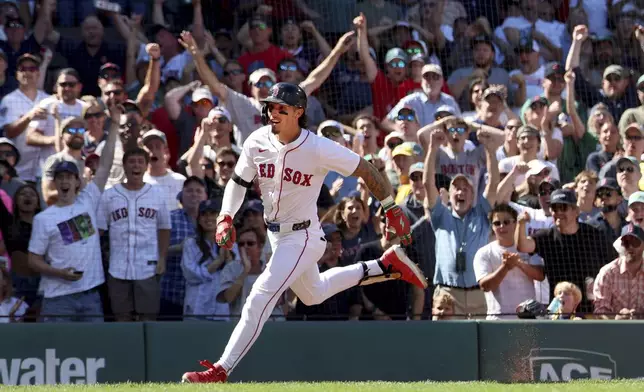 Fans cheer as Boston Red Sox's Jarren Duran runs to home plate to score after hitting a three-run in field home run during the fifth inning of a baseball game against the Pittsburgh Pirates, Sunday, Aug. 31, 2025, in Boston. (AP Photo/Mark Stockwell)