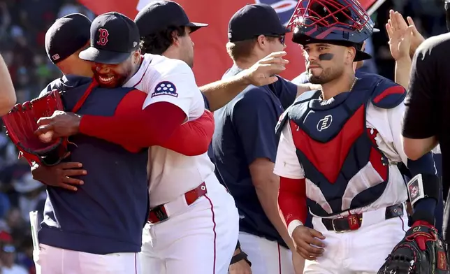 Boston Red Sox pitcher Aroldis Chapman, second from left, and catcher Carlos Narváez, right, celebrate with teammates and coaches after defeating the Pittsburgh Pirates in a baseball game Sunday, Aug. 31, 2025, in Boston. (AP Photo/Mark Stockwell)