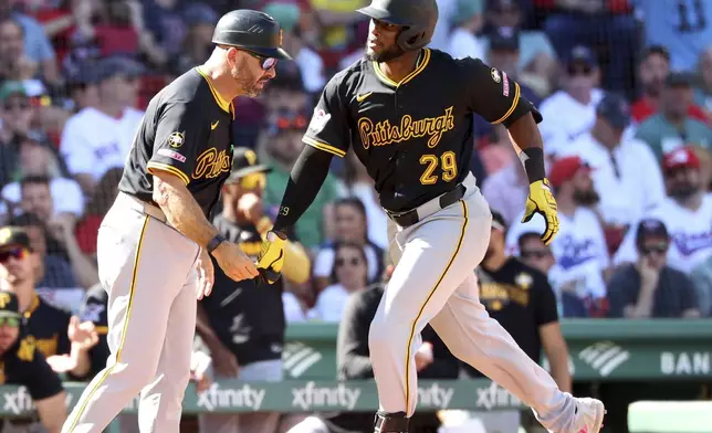 Pittsburgh Pirates' Alexander Canario (29) high fives third base coach Mike Rabelo after hitting a home run during the seventh inning of a baseball game against the Boston Red Sox, Sunday, Aug. 31, 2025, in Boston. (AP Photo/Mark Stockwell)