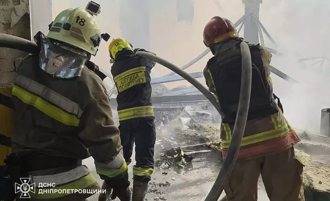 In this photo provided by the Ukrainian Emergency Services on Saturday, Sept. 20, 2025, rescue workers put out a fire of a residential house damaged by a Russian strike on Dnipro, Ukraine. (Ukrainian Emergency Service via AP)