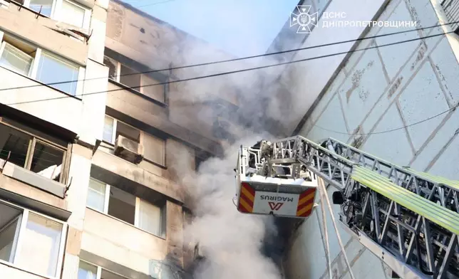 In this photo provided by the Ukrainian Emergency Services on Saturday, Sept. 20, 2025, a rescue worker puts out a fire of a residential house damaged by a Russian strike on Dnipro, Ukraine. (Ukrainian Emergency Service via AP)