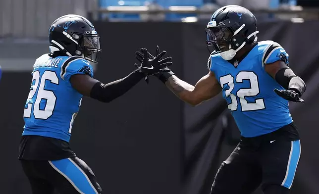 Carolina Panthers cornerback Chau Smith-Wade celebrates after scoring on an interception with linebacker Trevin Wallace against the Atlanta Falcons during the second half of an NFL football game, Sunday, Sept. 21, 2025, in Charlotte, N.C. (AP Photo/Rusty Jones)