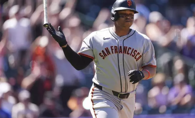 San Francisco Giants' Rafael Devers tosses his bat as he heads up the first base line after hitting a solo home run off Colorado Rockies starting pitcher Chase Dollander in the first inning of a baseball game Monday, Sept. 1, 2025, in Denver. (AP Photo/David Zalubowski)