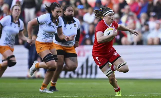 Canada's Karen Paquin, right, breaks away to score a try during the Women's Rugby World Cup 2025 quarterfinal match between Canada and Australia, in Bristol, England, Saturday, Sept. 13, 2025. (AP Photo/Anthony Upton)
