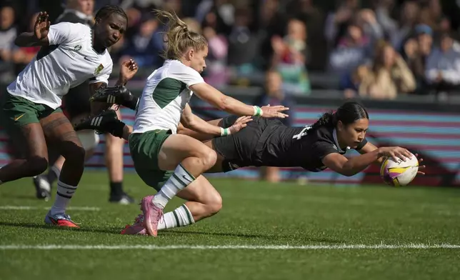 New Zealand's Braxton Sorensen-McGee, right, scores a try as South Africa's Nadine Roos, center, tries to defend during the Women's Rugby World Cup 2025 quarterfinal match between New Zealand and South Africa, in Exeter, England, Saturday, Sept. 13, 2025. (AP Photo/Alastair Grant)