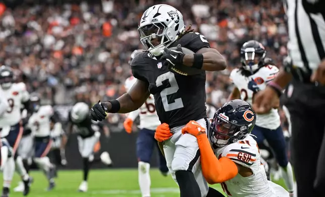 Las Vegas Raiders running back Ashton Jeanty (2) is grabbed by Chicago Bears free safety Kevin Byard (31) as he runs toward the end zone for a touchdown during the first half of an NFL game, Sunday, Sept. 28, 2025, in Las Vegas. (AP Photo/David Becker)