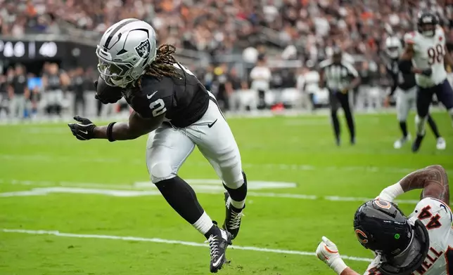 Las Vegas Raiders running back Ashton Jeanty (2) evades a tackle from Chicago Bears linebacker Noah Sewell (44) to score a touchdown during the first half of an NFL football game Sunday, Sept. 28, 2025, in Las Vegas. (AP Photo/John Locher)