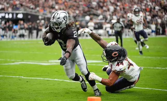 Las Vegas Raiders running back Ashton Jeanty (2) evades a tackle from Chicago Bears linebacker Noah Sewell (44) to score a touchdown during the first half of an NFL football game Sunday, Sept. 28, 2025, in Las Vegas. (AP Photo/John Locher)