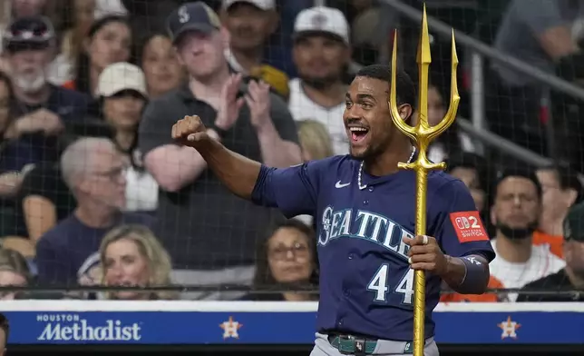 Seattle Mariners' Julio Rodríguez celebrates after a solo home run by teammate Josh Naylor during the eighth inning of a baseball game against the Houston Astros, Friday, Sept. 19, 2025, in Houston. (AP Photo/Kevin M. Cox)