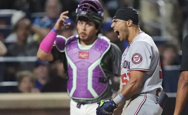 New York Mets catcher Francisco Alvarez, left, watches as Washington Nationals' Daylen Lile (51) celebrates after hitting a two-run inside-the-park home run during the 11th inning of a baseball game Saturday, Sept. 20, 2025, in New York. (AP Photo/Frank Franklin II)