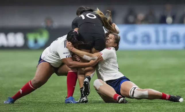 FILE - New Zealand's Atlanta Lolohea, center, is stopped by France's Ambre Mwayembe, left, and Axelle Berthoumieu, right, during the WXV women's rugby union tournament, in Vancouver, on Oct. 12, 2024. (Ethan Cairns/The Canadian Press via AP, File)