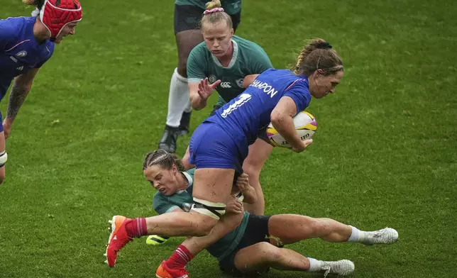 France's Pauline Bourdon Sansus, right, is tackled by Ireland's Aoife Wafer, bottom, and her teammate Dannah O'Brien during a Women's Rugby World Cup 2025 quarterfinal match between France and Ireland, in Exeter, England, Sunday, Sept. 14, 2025. (AP Photo/Alastair Grant)