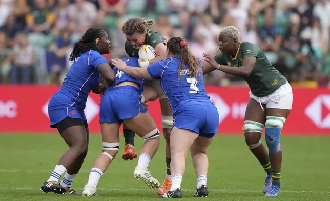 South Africa's Catha Jacobs, center, is tackled by France's Rose Bernadou and Manae Feleu during the Women's Rugby World Cup 2025 pool D match between France and South Africa in Northampton, England, Sunday, Sept. 7, 2025. (Joe Giddens/PA via AP)
