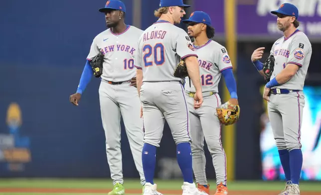 New York Mets third baseman Ronny Mauricio (10), first baseman Pete Alonso (20), shortstop Francisco Lindor (12) and second baseman Jeff McNeil, right, stand Lon the field during a pitching change in the fourth inning of a baseball game, Sunday, Sept. 28, 2025, in Miami. (AP Photo/Lynne Sladky)