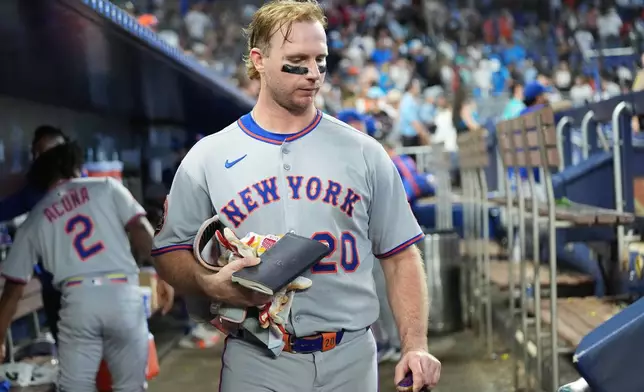 New York Mets' Pete Alonso gathers his belongings in the dugout after the Mets lost to the Miami Marlins in a baseball game, Sunday, Sept. 28, 2025, in Miami. (AP Photo/Lynne Sladky)
